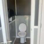 image shows the interior of a portable restroom, specifically a luxury or high-end portable toilet unit, likely designed for events or locations