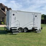 image shows a portable restroom trailer, also known as a luxury portable toilet or a VIP toilet van